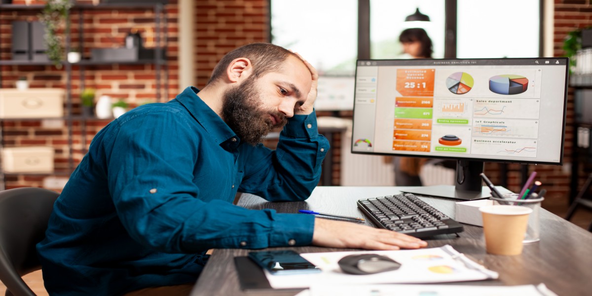 Tired office worker stressed while analyzing business data on compute